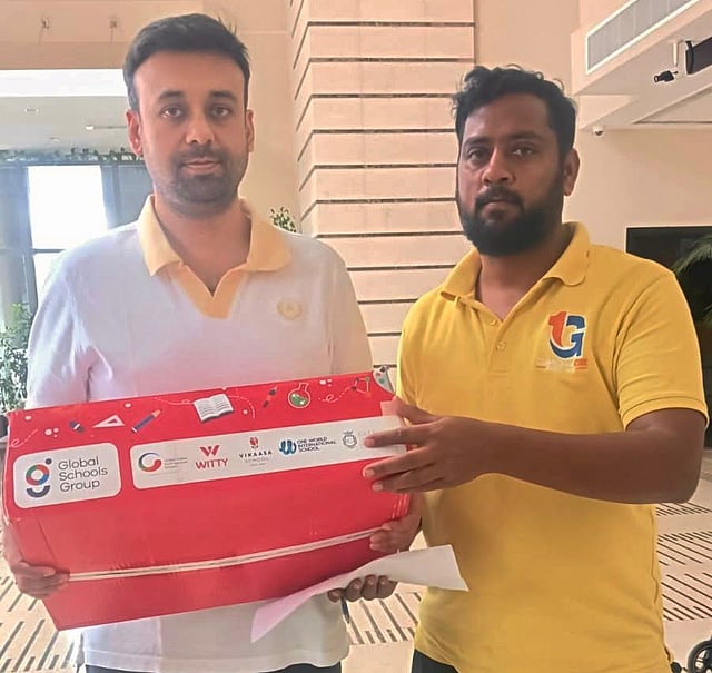 A parent receives books sent by Global Indian International School. 